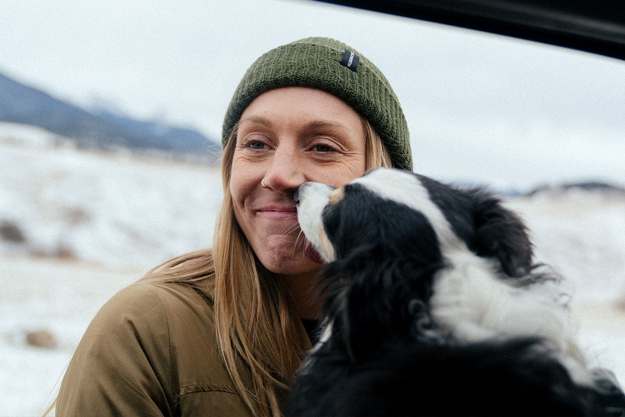 A woman and her dog in the snow.