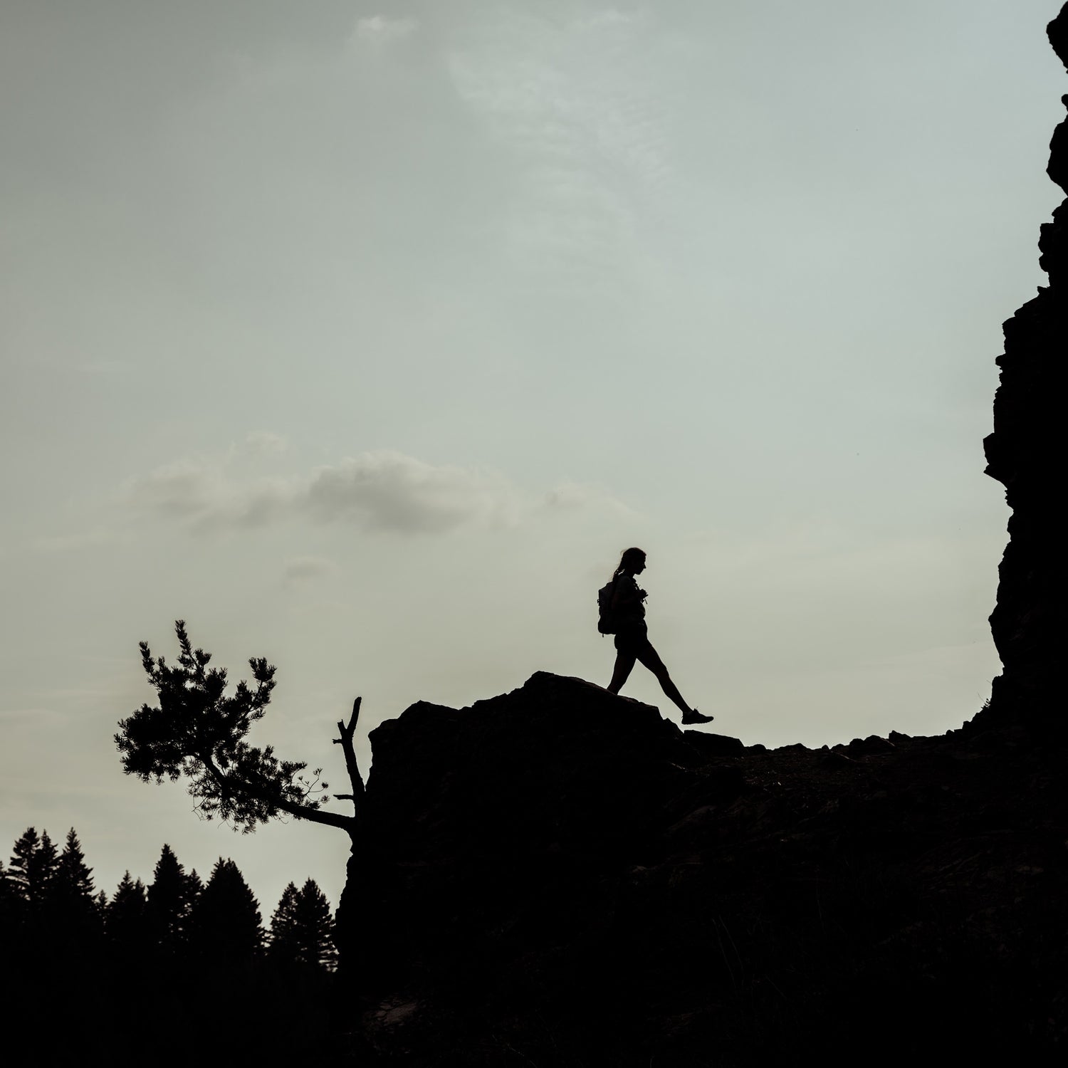 A woman hiking on a mountain ridge.