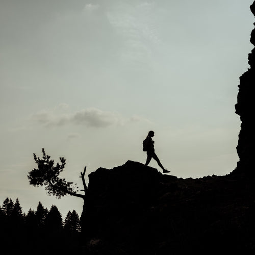 A woman hiking on a mountain ridge.