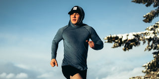 A man running while wearing merino wool layers.