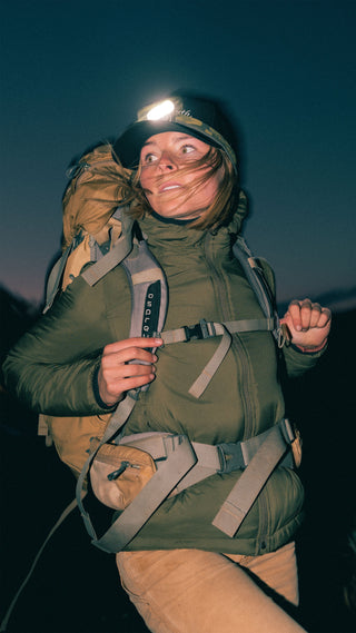 A woman hiking wearing merino wool layers.