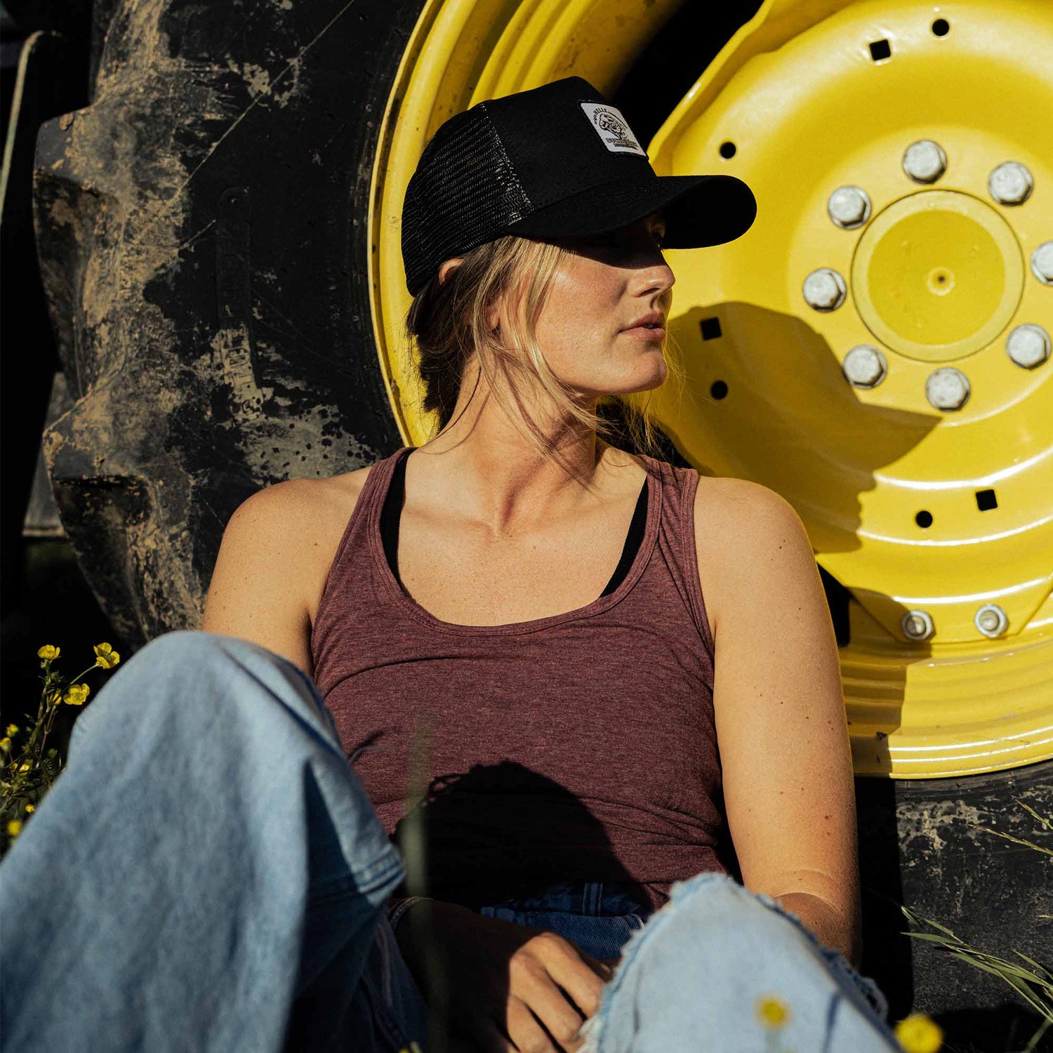 A woman wearing a black American made trucker hat with a Duckworth patch on it.