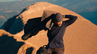 A man hiking a mountain in wool layers.