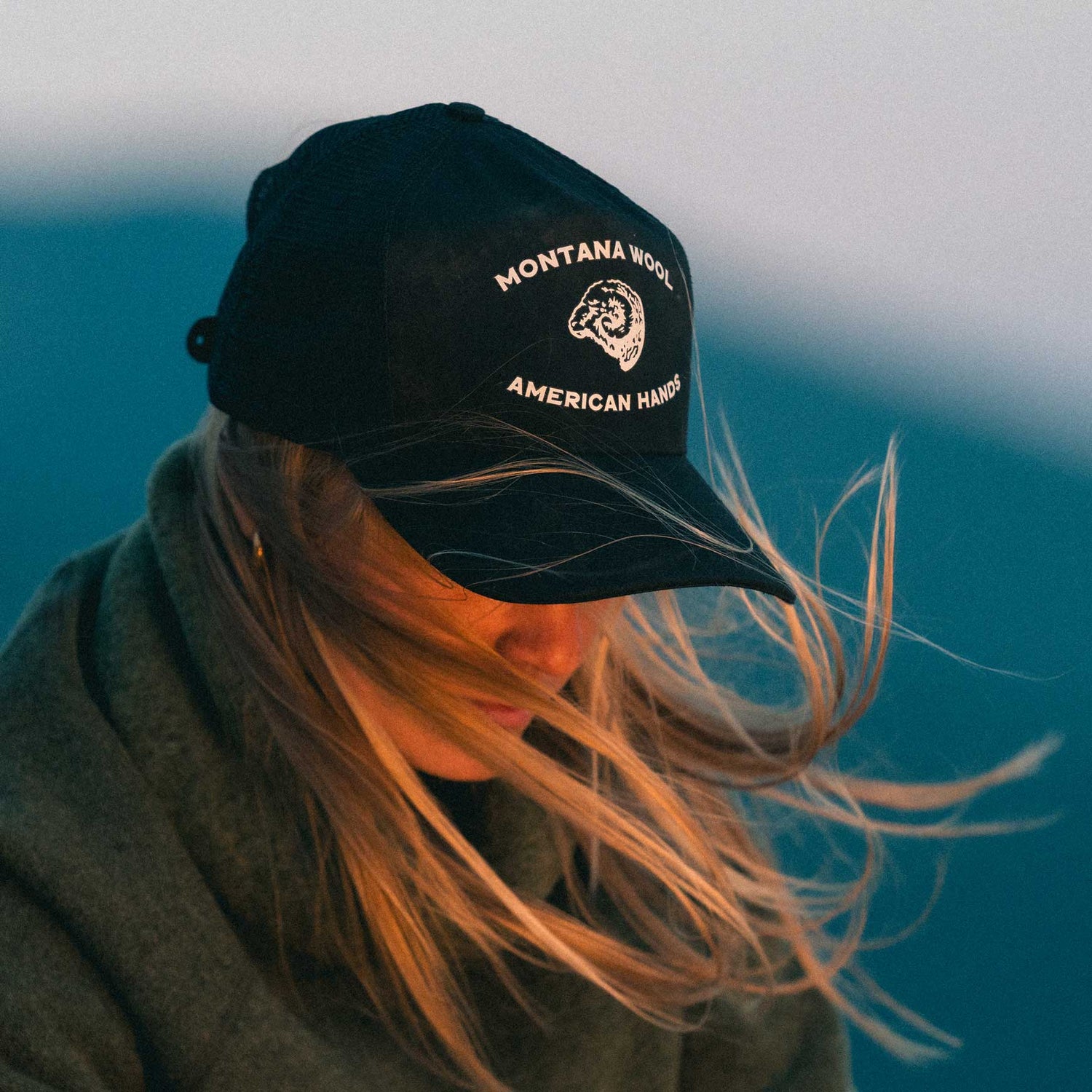 A woman wearing a blue ball cap with a Montana logo on it.