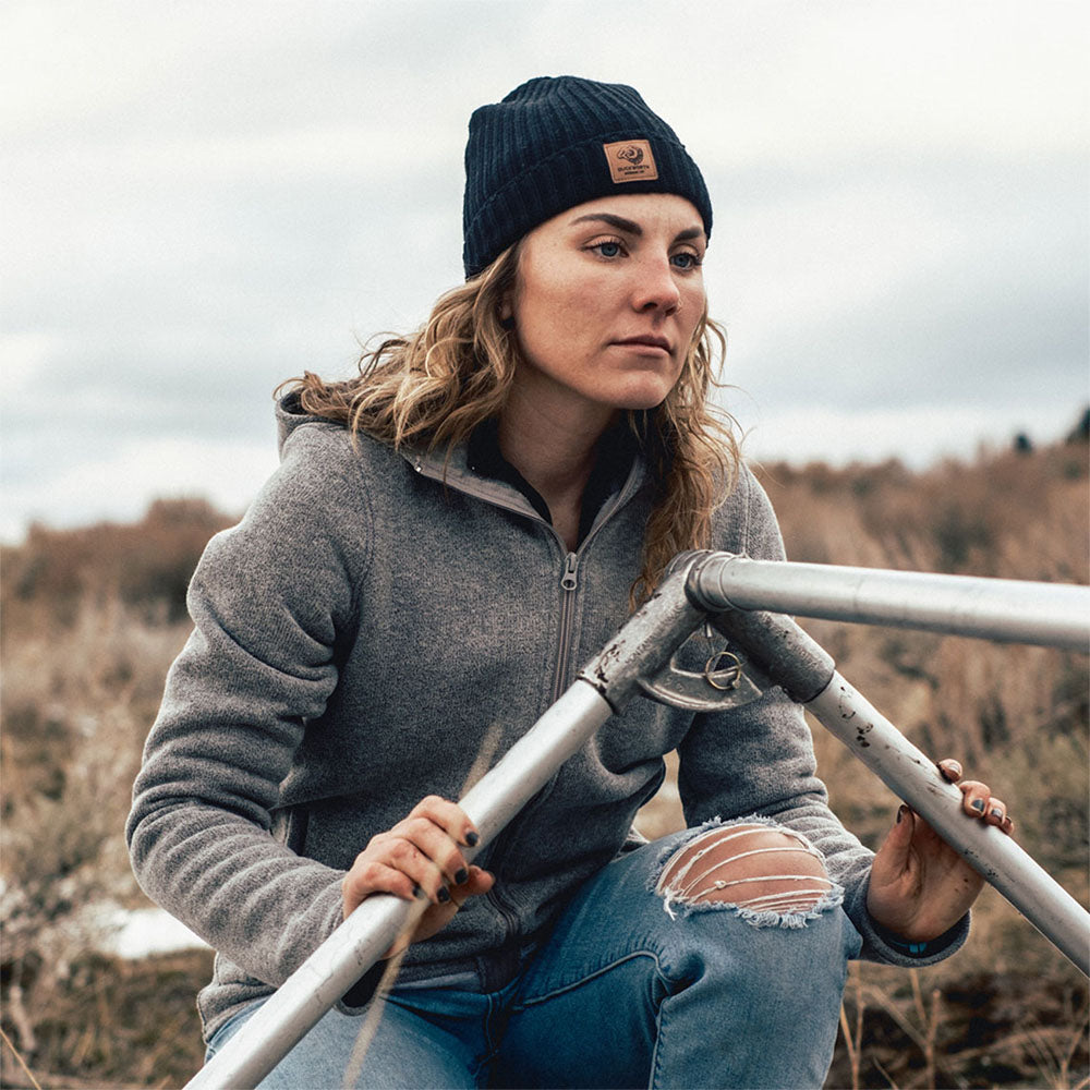 Woman wearing black made in America merino wool knit hat with leather patch. 