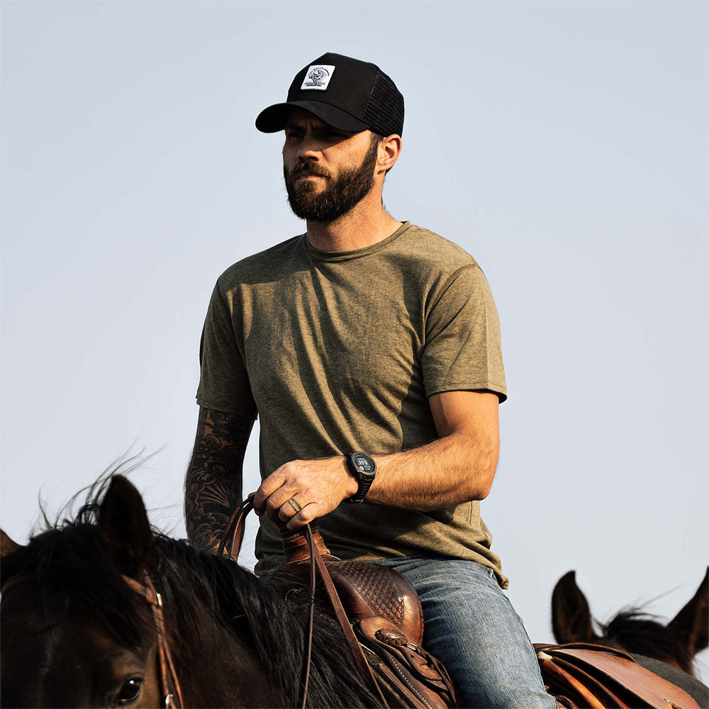 A rancher wearing a green American made Duckworth merino wool light weight tee shirt.