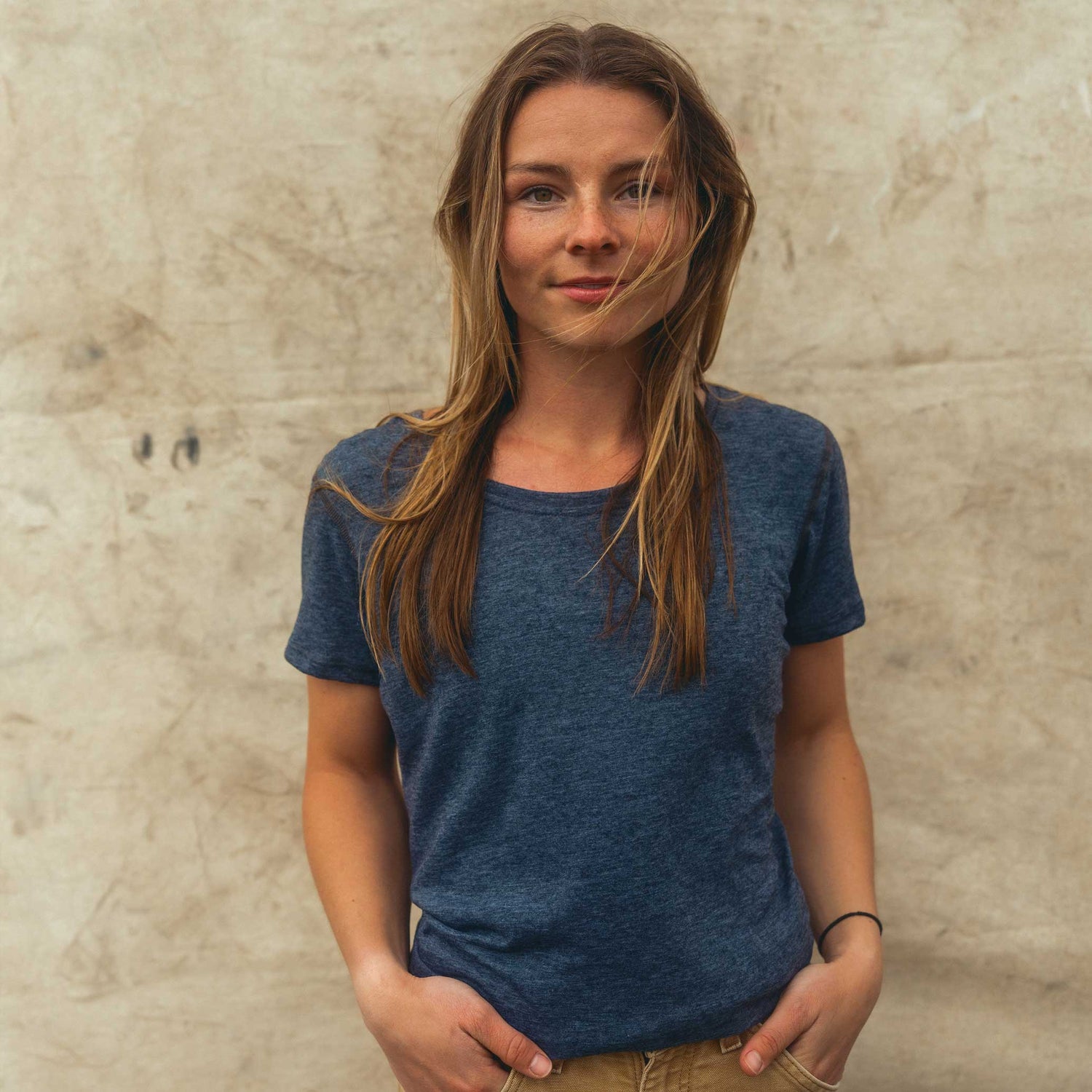 A woman wearing a charcoal gray American made Duckworth merino wool performance tee shirt.