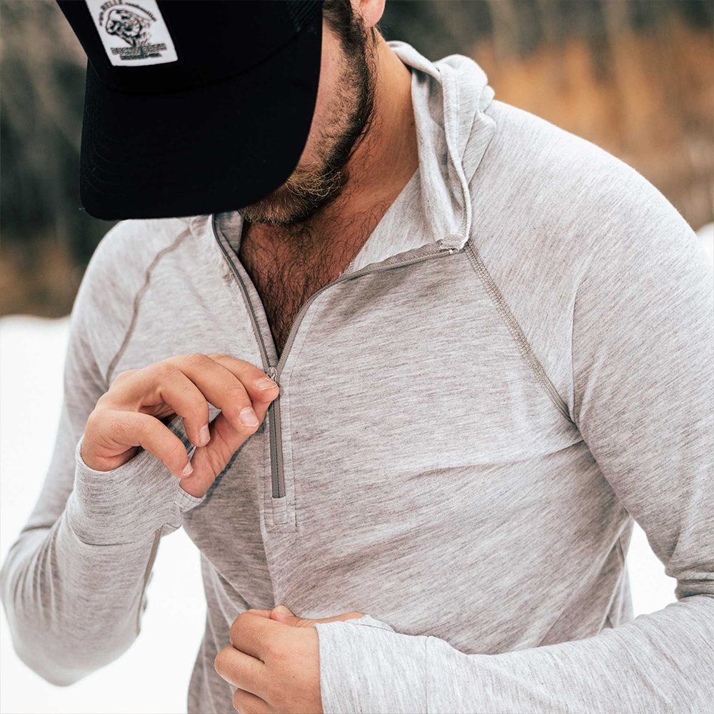 A man wearing a gray American made Duckworth merino wool exercise hoody.