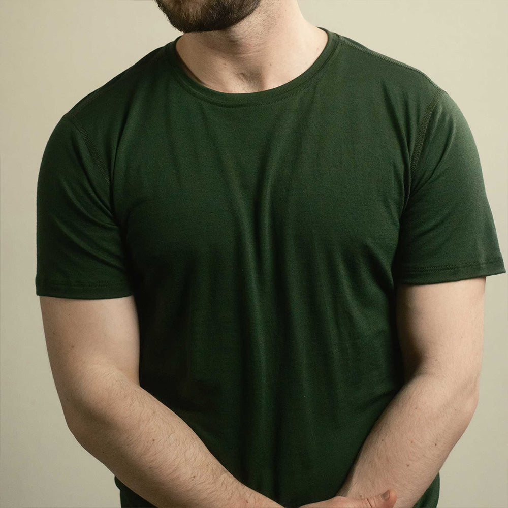 A man wearing a green American made Duckworth merino wool tee shirt. 