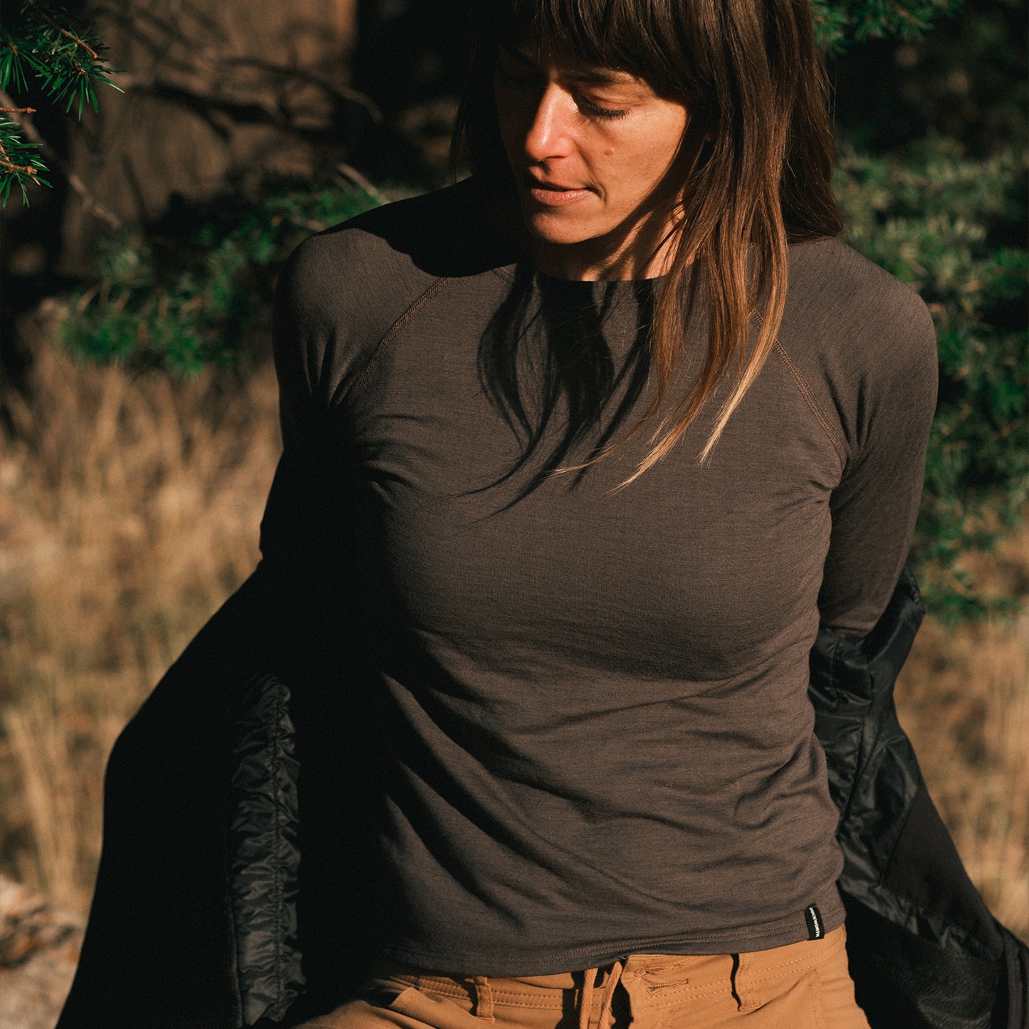 A woman wearing a gray American made Duckworth merino wool long sleeve base layer.