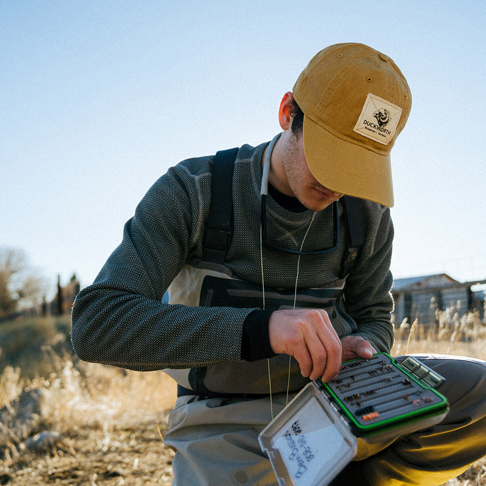 fisherman in duckworth hat sorts lures